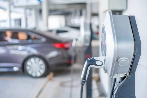 Cargador para coche eléctrico instalado en plaza de parking en sótano comunitario en Barcelona con canalización vista en techo