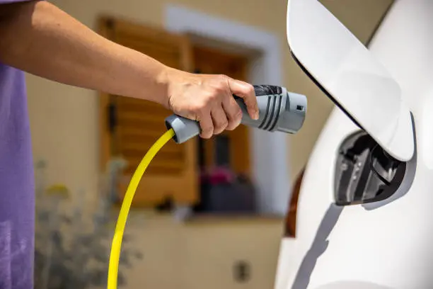 Cargador para coche eléctrico instalado en garaje exterior de chalet en Castelldefels con canalización discreta en fachada y acabado limpio