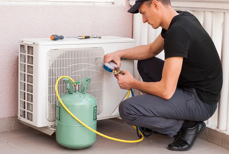 Técnico reparando fuga de gas en equipo de aire acondicionado en vivienda del Baix Llobregat